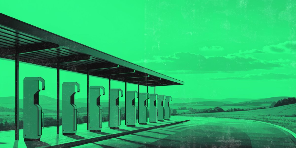 A long row of rapid EV chargers at a roadside charging hub beneath a wide canopy with open landscape behind