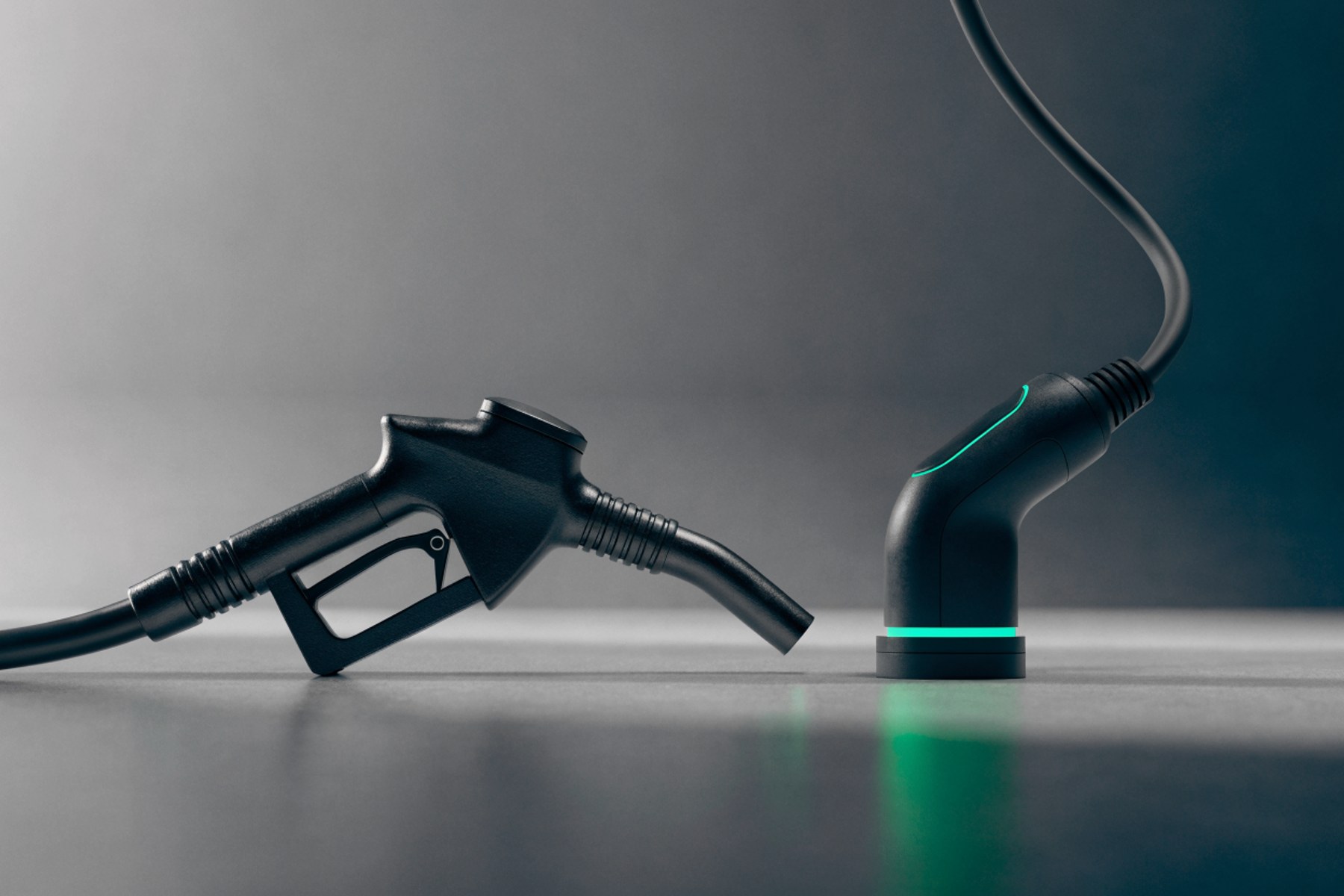 A fuel nozzle and a charging cable side by side on a charcoal surface