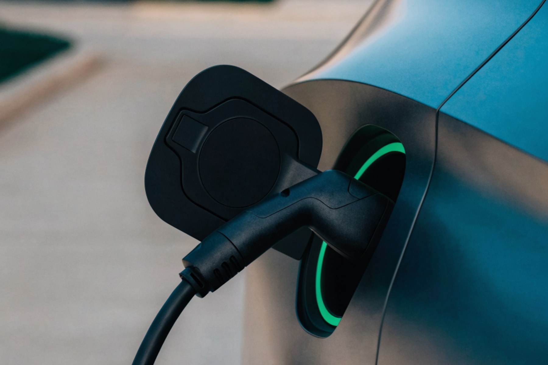An electric car charging port close-up with a green ring of light
