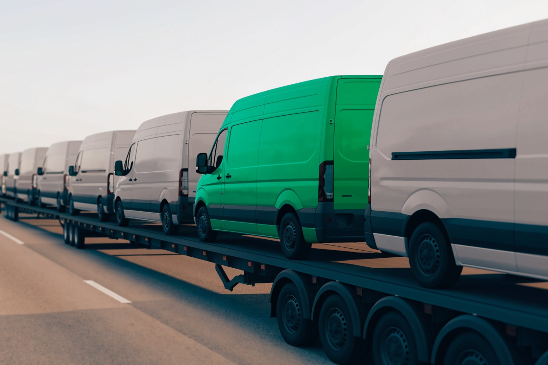 A row of new vans on a transporter, one of them green